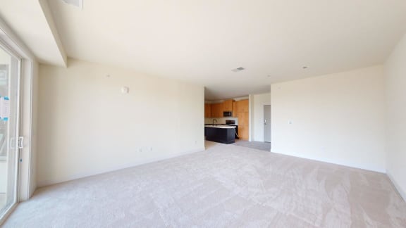 an empty living room with a kitchen in it