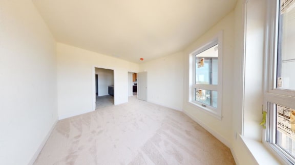 a living room with white walls and a large window