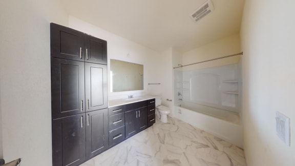a bathroom with black cabinets and a sink and a toilet