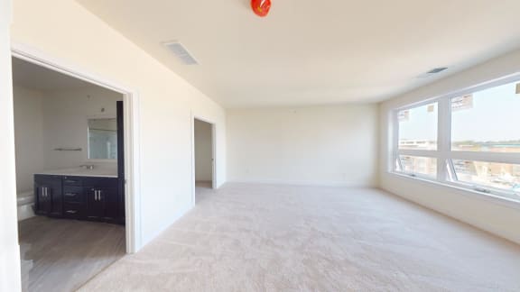 an empty living room with a large window and a sink