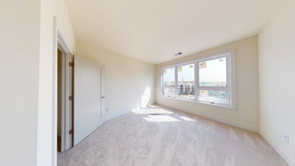 a bedroom with a large window and a closet