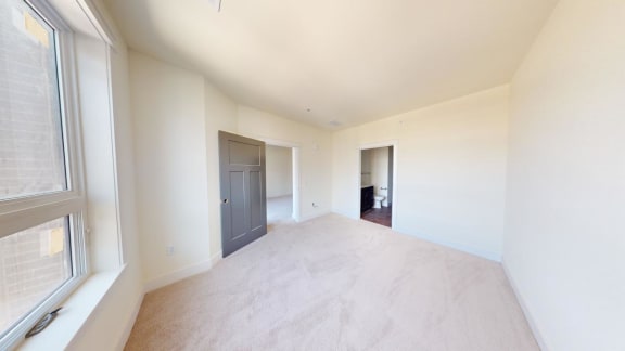 an empty living room with a window and a door