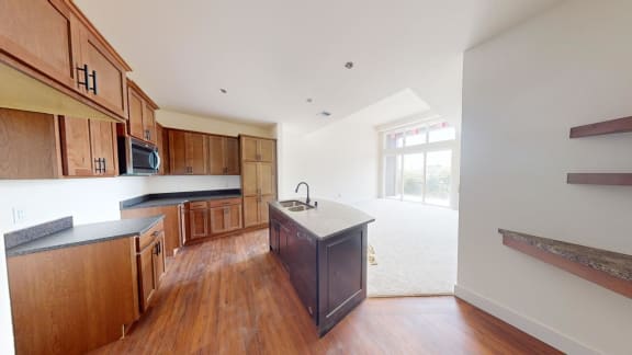 a large kitchen with wooden cabinets and a large window