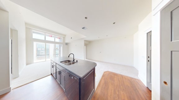 a kitchen with a sink in a large empty room