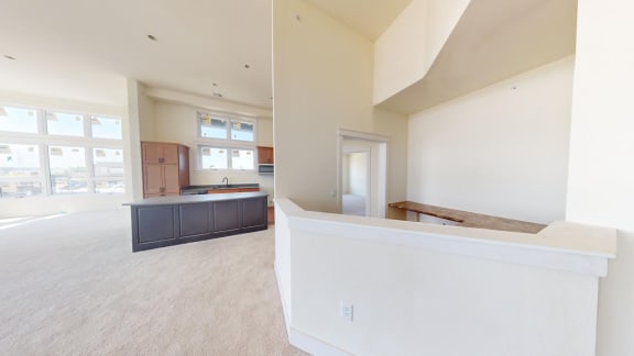 an empty living room and kitchen with a counter top