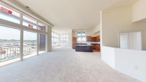a large living room with a kitchen and a balcony