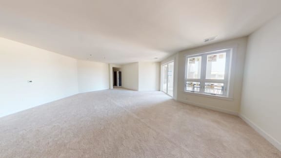 the living room and dining room of an empty home with a large window