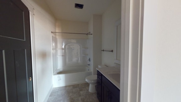 a bathroom with a shower and a toilet and a sink