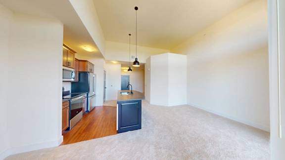 A kitchen with a refrigerator, microwave, and oven is visible.