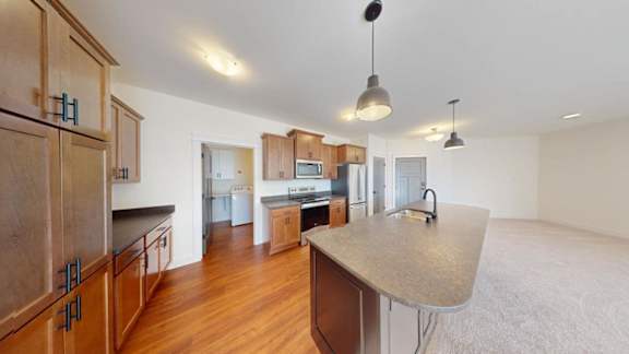 A kitchen with wooden cabinets and a large island.