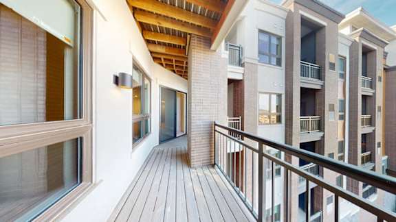 A balcony with a railing and a building in the background.