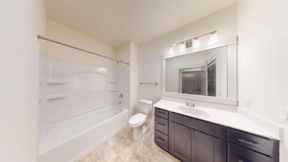 A white bathroom with a toilet, sink, and mirror.