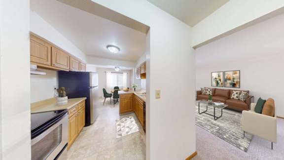 A kitchen with a refrigerator, a dining table with chairs, and a living room with a couch.