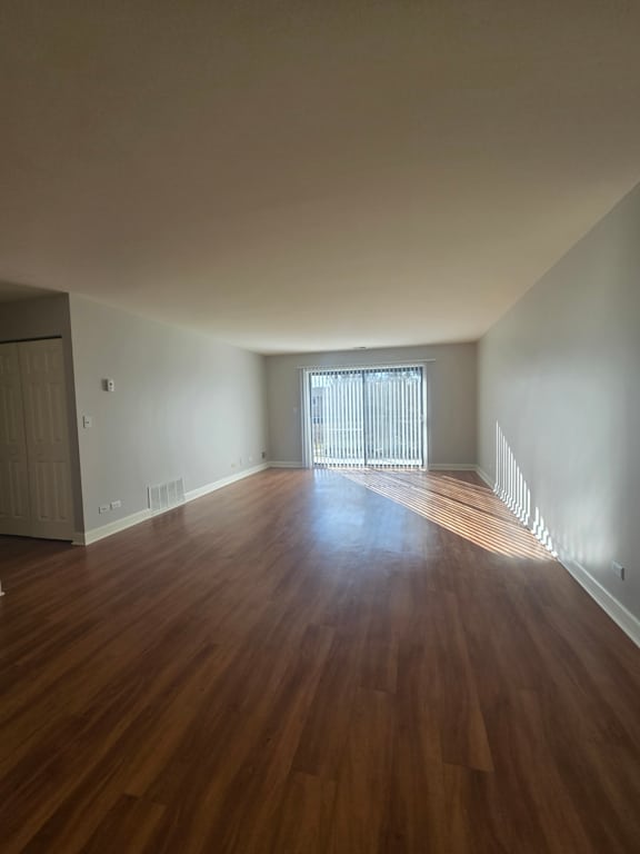 A room with a white cabinet and a window with blinds.