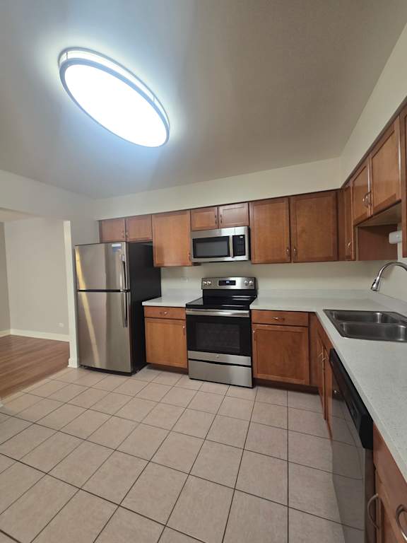 A kitchen with a stainless steel refrigerator and microwave.