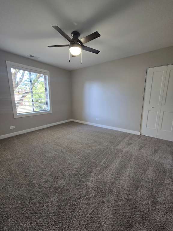 A ceiling fan in a room with a window.
