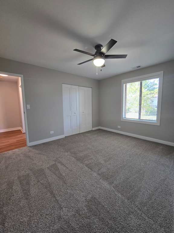 A ceiling fan is mounted on a wall in a room with a skylight.