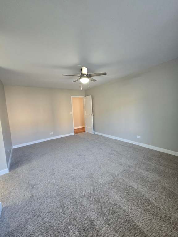 A stairwell with a light on the wall and a carpeted stair.