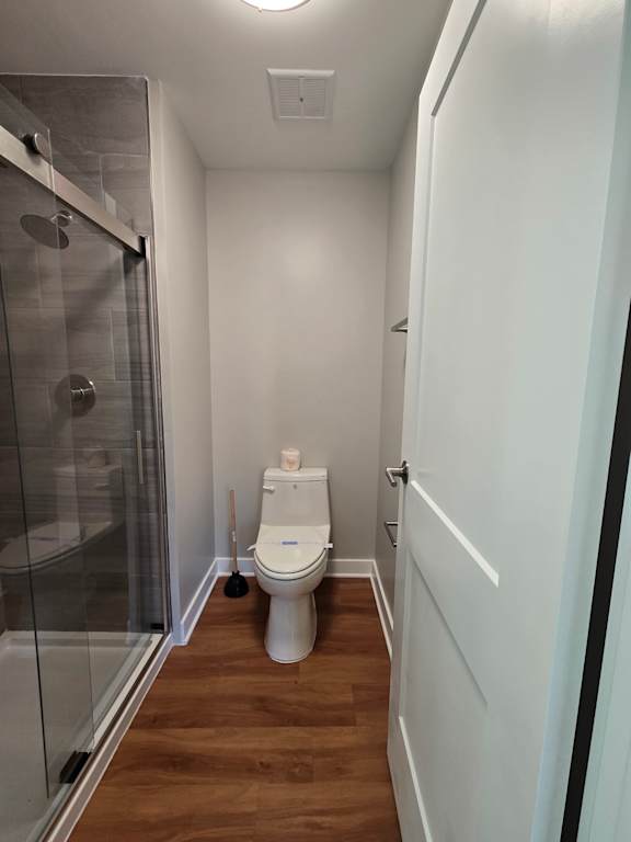 A modern bathroom with a glass shower stall and a white ceiling.