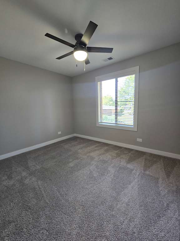 A ceiling fan in a room with a window.