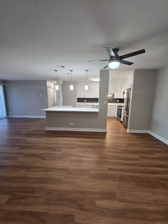 A room with a ceiling fan and wooden flooring.
