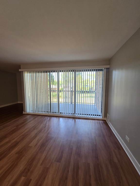 A room with a window covered by white blinds.