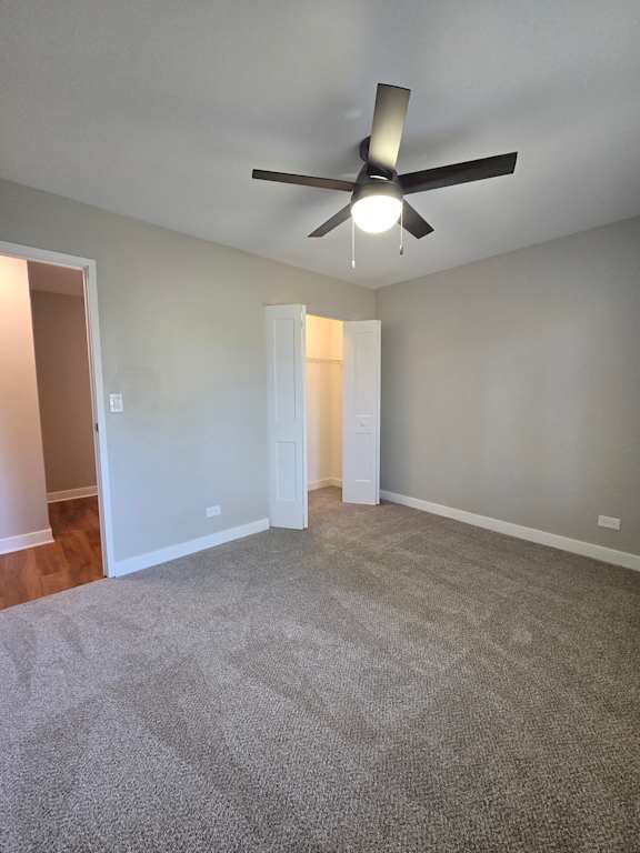 A ceiling fan with lights is mounted on a white wall above a white shelf.