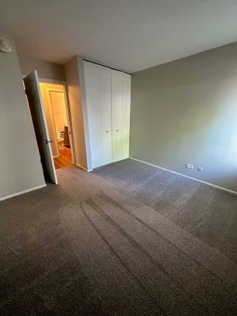 an empty room with a carpeted floor and a door