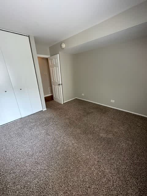 an empty bedroom with a closet and a door