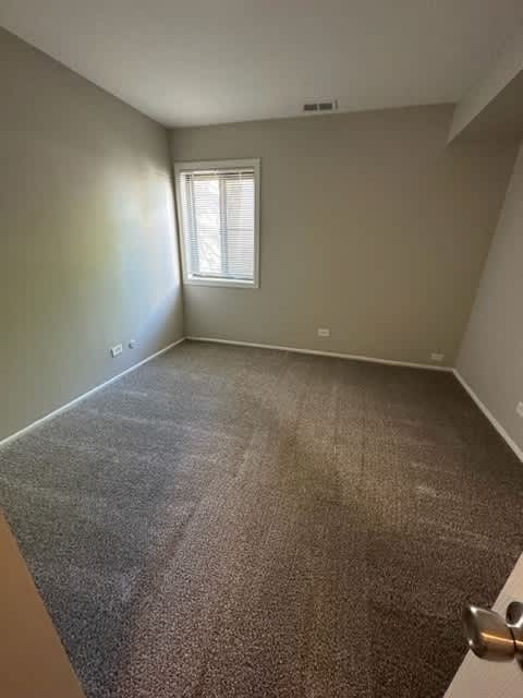 an empty room with carpet and a window