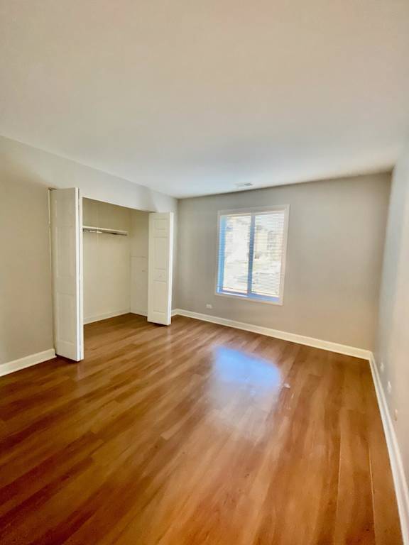 A room with wooden flooring and a window.