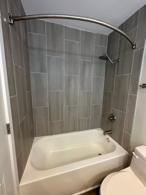 a white bath tub sitting next to a toilet