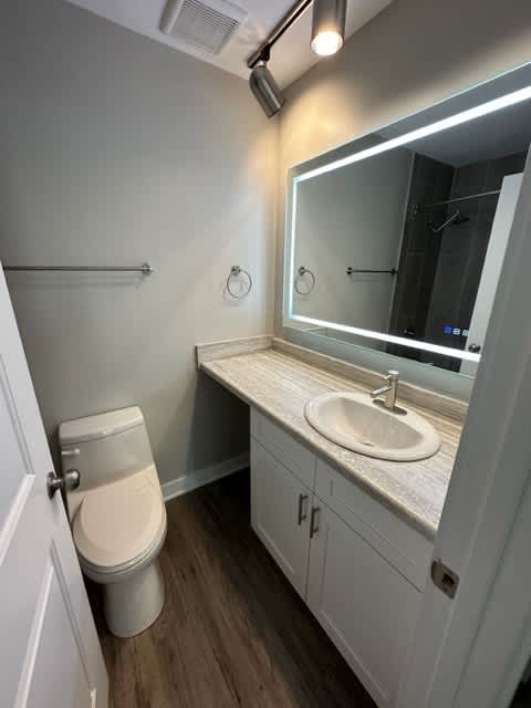 a bathroom with a toilet sink and mirror