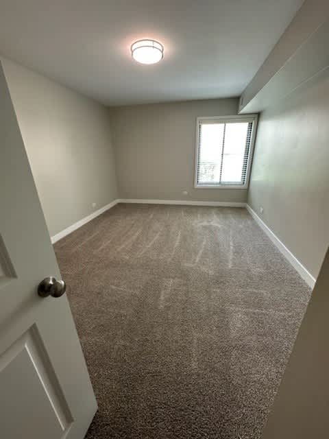 an empty room with a window and a door