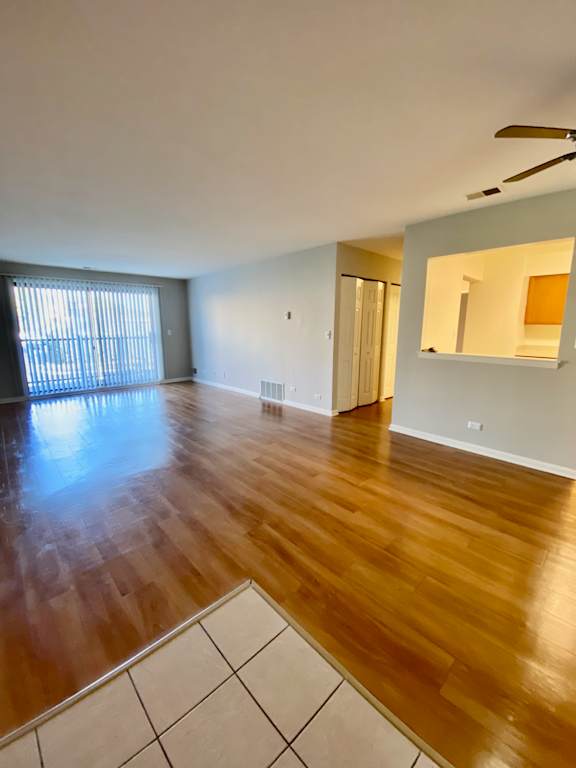 A room with wooden flooring and a ceiling fan.