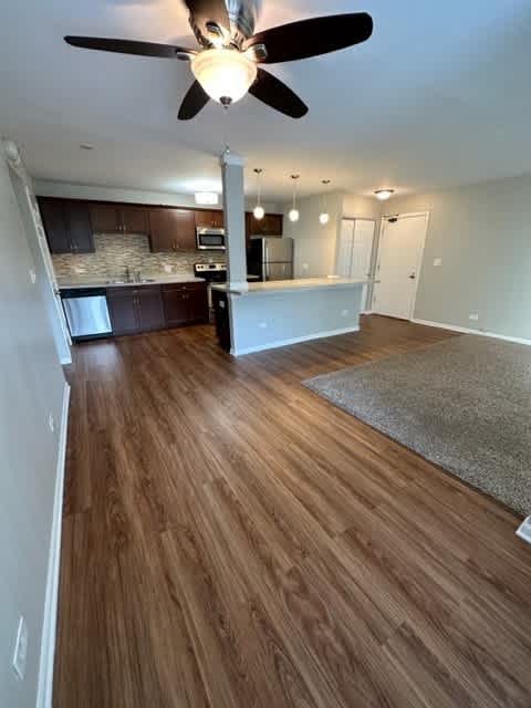 a kitchen and living room with a ceiling fan
