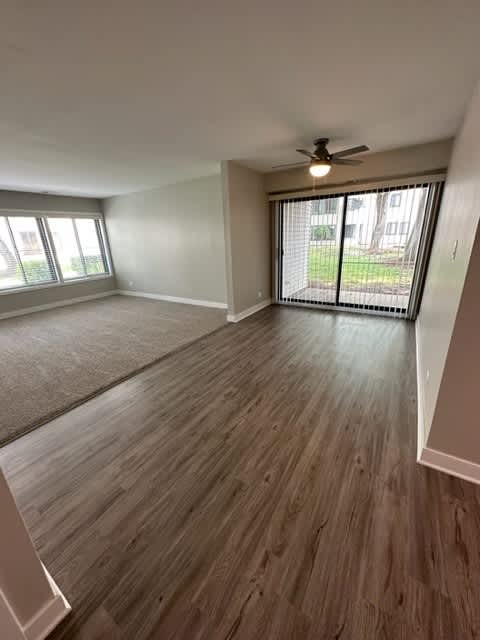 an empty living room with a ceiling fan