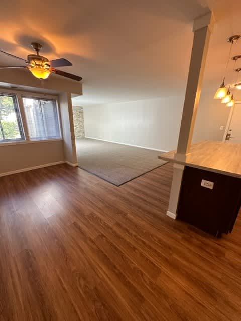 an empty living room with a ceiling fan