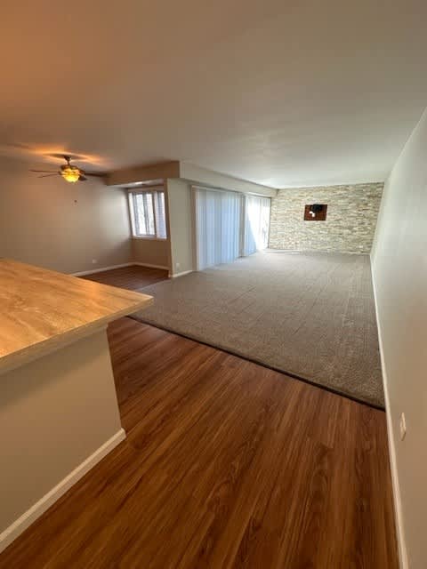 an empty living room with a rug and a ceiling fan