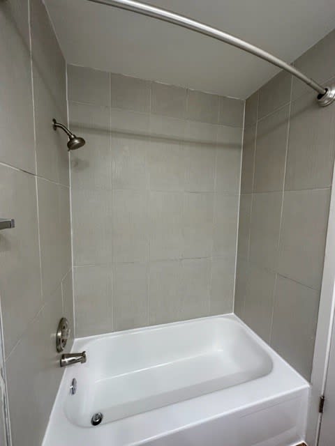 a white bath tub sitting next to a shower