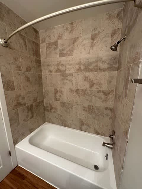a small bathroom with a shower and a white tub