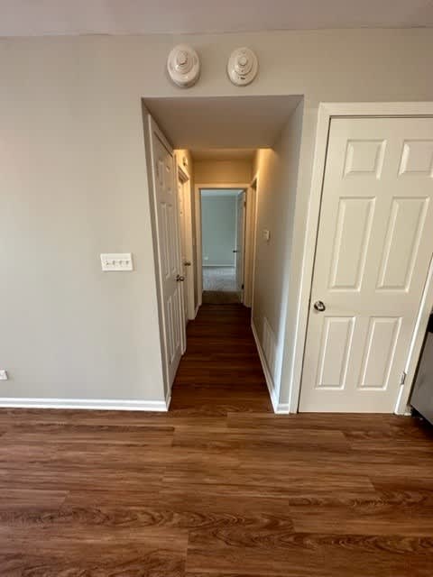 a hallway with a wooden floor and a white door
