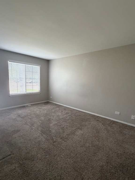 A small window in a room with a grey wall.
