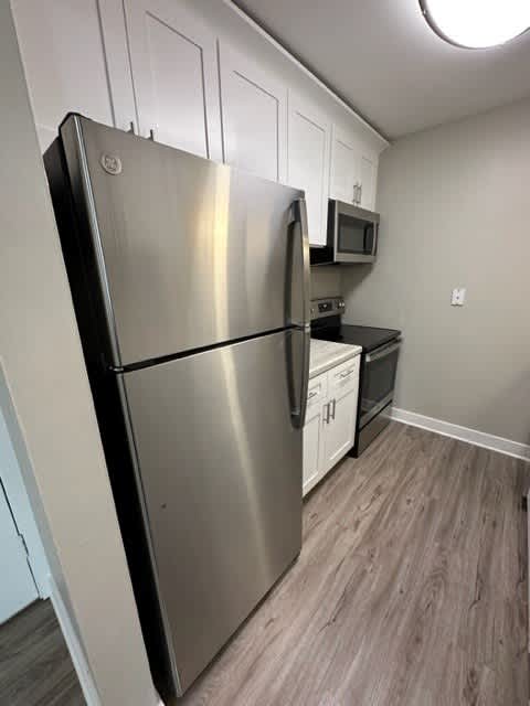 a kitchen with a refrigerator a stove and a microwave