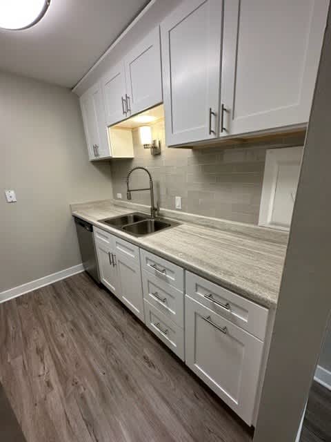 a kitchen with white cabinets and a sink