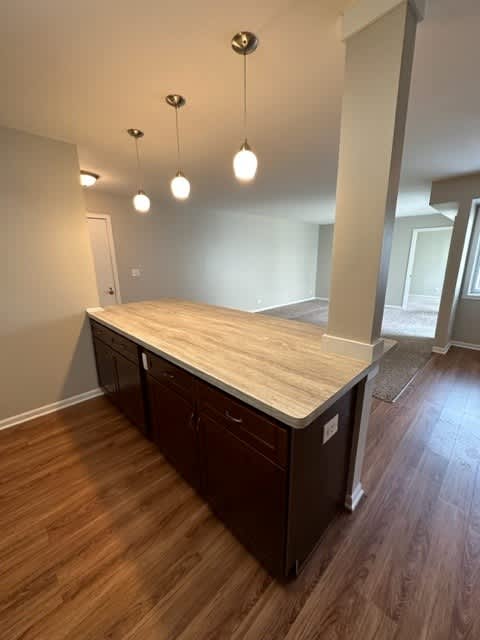 a kitchen with a counter top on top of a wooden floor
