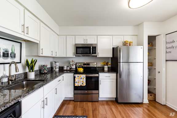 A kitchen with white cabinets and a black stove top oven.