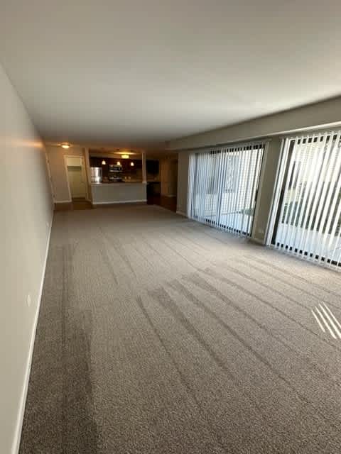 an empty living room with blinds on the window