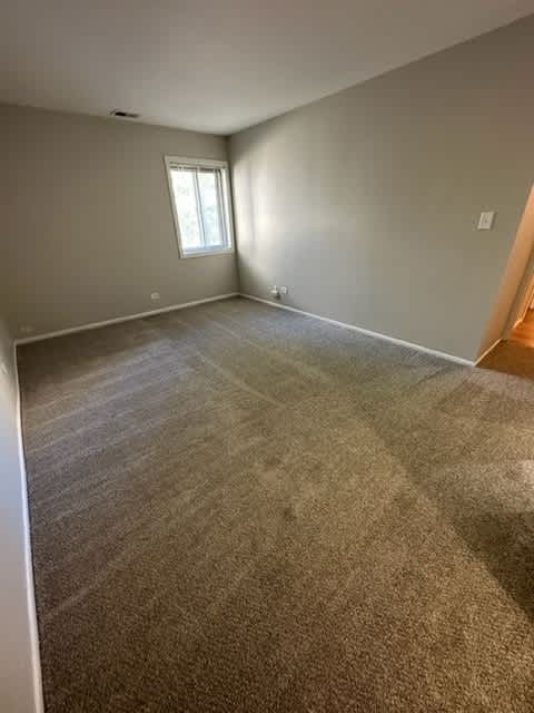 an empty room with a carpeted floor and a window