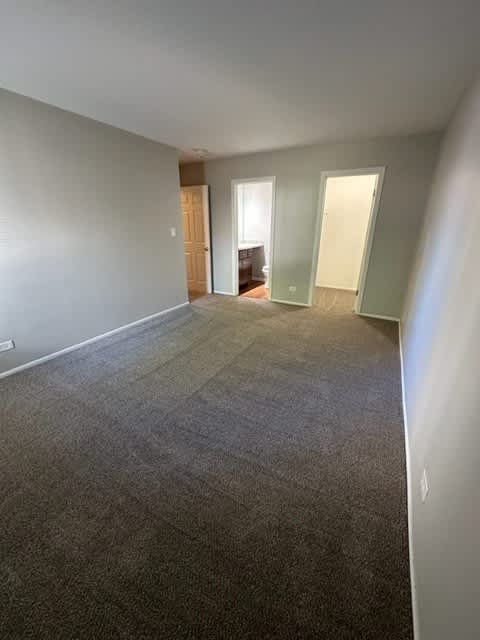 an empty living room with a carpeted floor